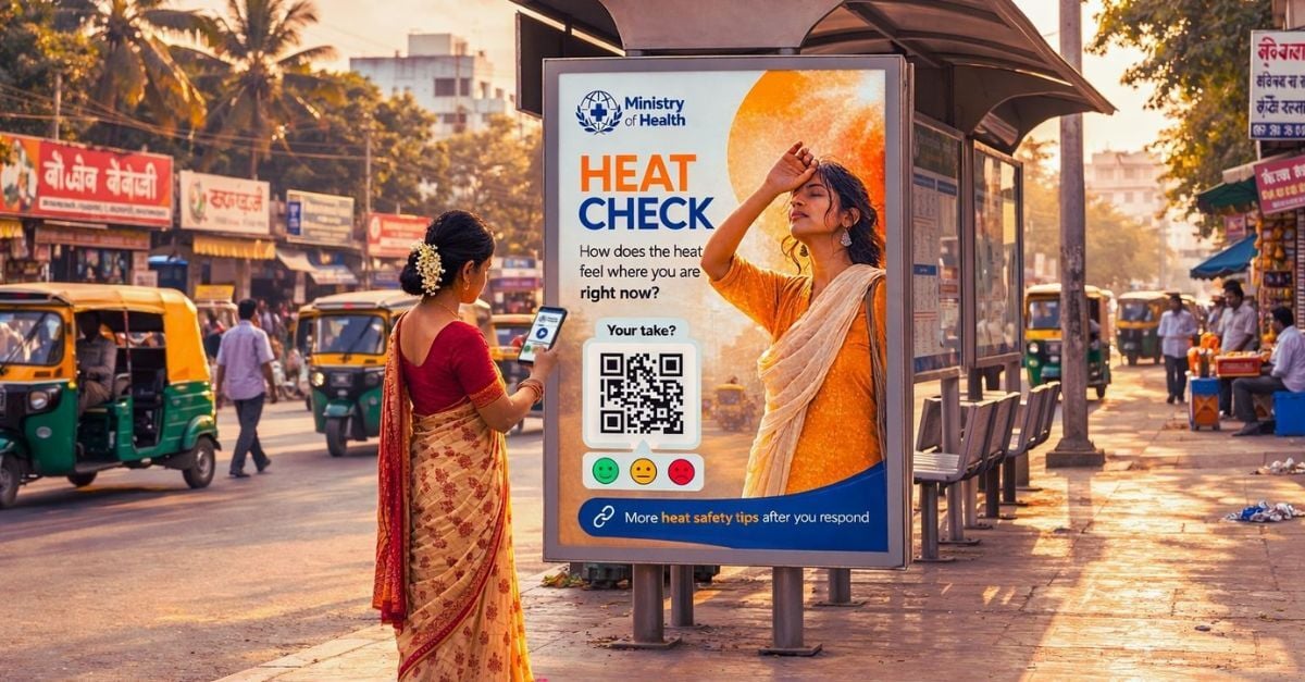 Woman in an Indian city scanning a QR code on a bus stop ambient feedback poster with her mobile phone 
